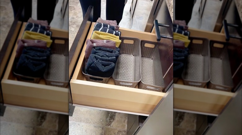 Kitchen towels organized in a drawer with baskets.