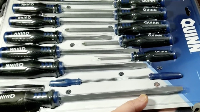 15-piece Quinn screwdriver set still in plastic packaging being unboxed.