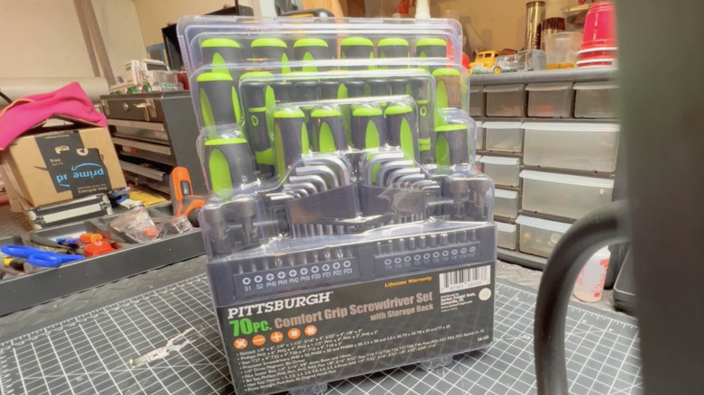 The 70-piece Pittsburgh screwdriver set still in its plastic packaging, snapped on top of a garage workstation.