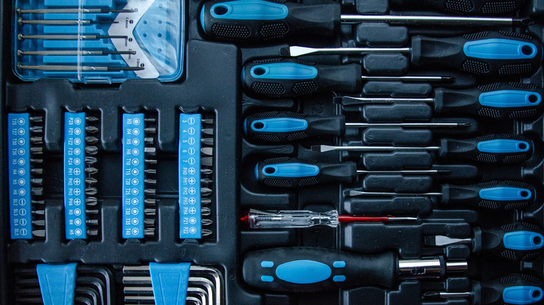 A complete multifunctional tool kit with screwdrivers, bits, hex keys, and precision tools organized in a sturdy case.