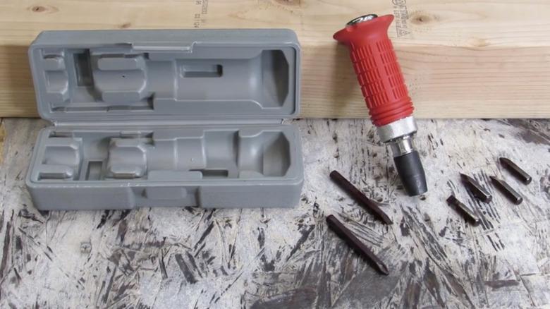 Pittsburgh impact screwdriver handle, bits, and case placed on concrete surface, with a piece of wood visible in the background.