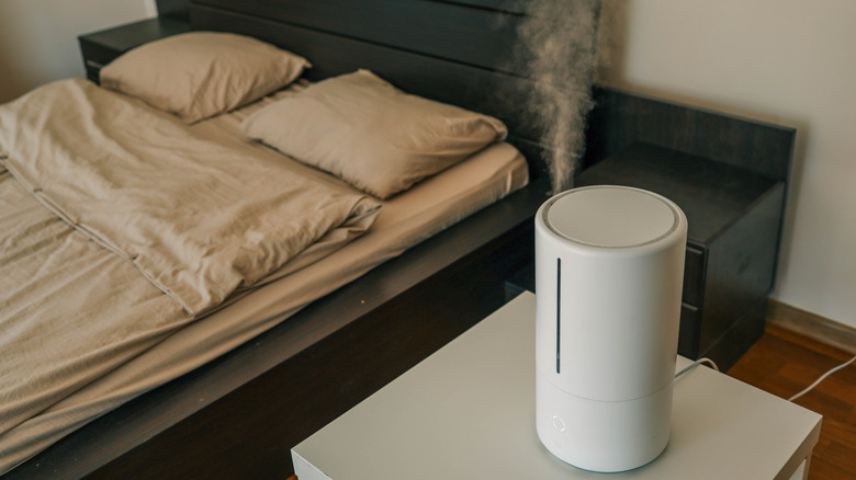 A humidifier releasing steam in a bedroom