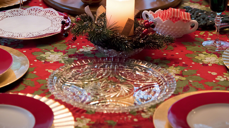 A Christmas tablescape with gold crinkle and yellow ceramic charger plates.