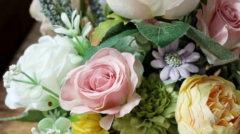 Artificial flowers and greenery made from plastic and fabric in a bouquet..