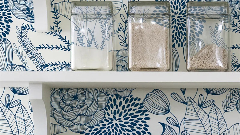 Blue and white wallpaper near open shelves