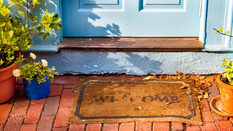Rustic coir door mat on porch.