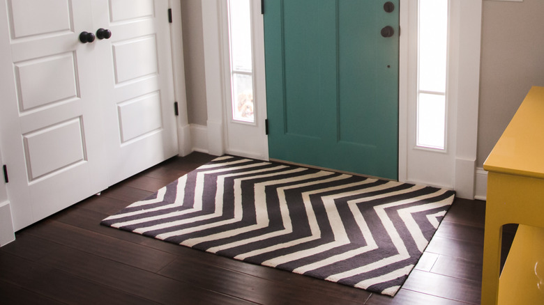 Woven rug in entry way with wood floor.