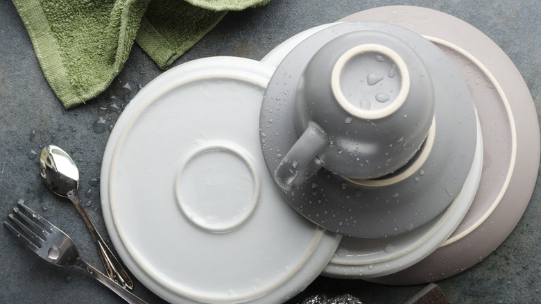 Wet dishes on a kitchen countertop alongside a towel