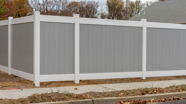 Two-toned, corner privacy vinyl fence in yard