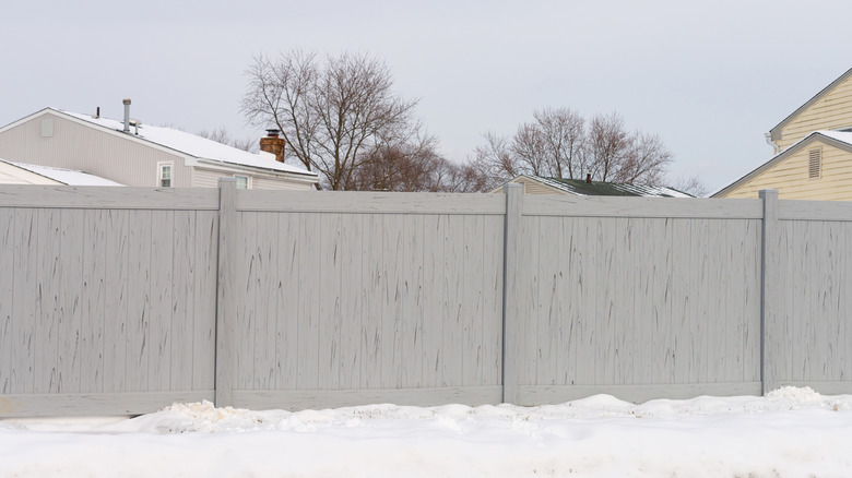 Vinyl fence in snow-covered yard
