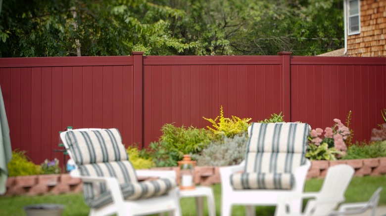 Vinyl fence in background, yard chairs in foreground