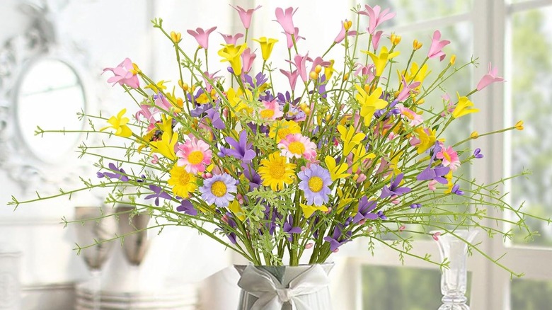 Faux forsythia and daisies in a vase