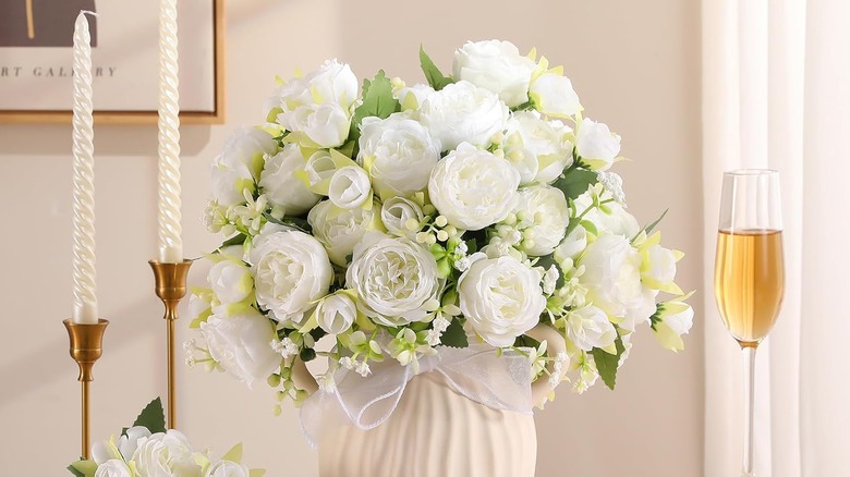 Faux white peonies in a vase on dining table