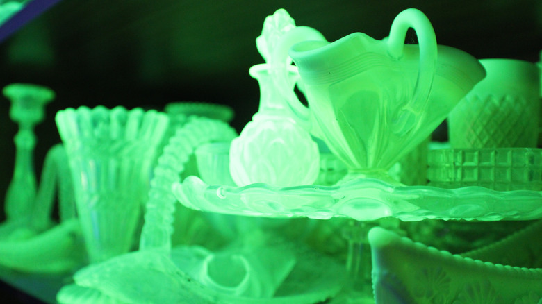 Uranium glass items glowing under a blacklight