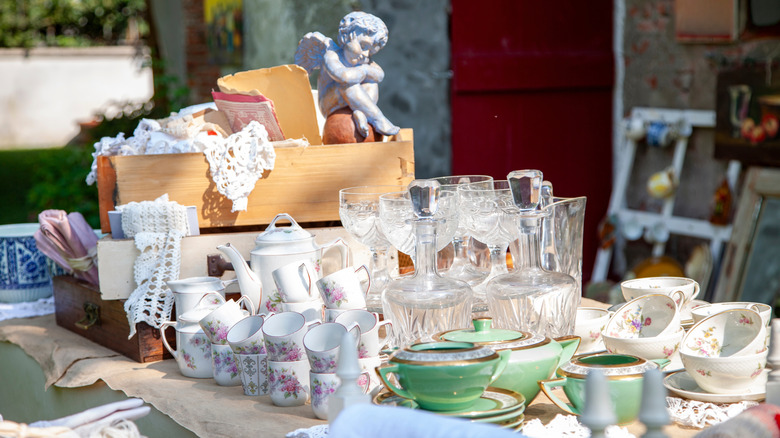 Crystal and porcelain items on a table outside for sale