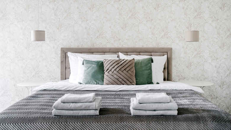Guest bedroom with stack of towels on the bed