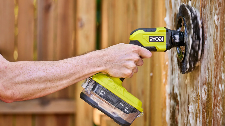 A person cleaning a fence with Ryobi's 18V One+ Cordless Vortex Power/Electric Spin Scrubber