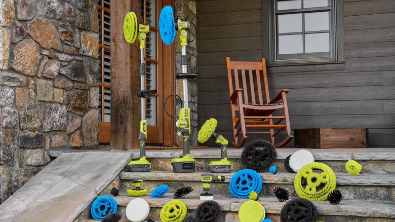 A line-up of Ryobi cleaning tools on the outside steps of a house