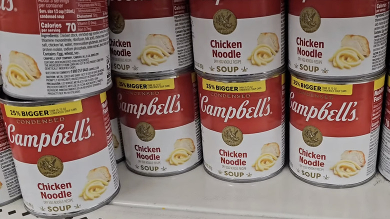 cans of chicken noodle soup stacked on store shelf