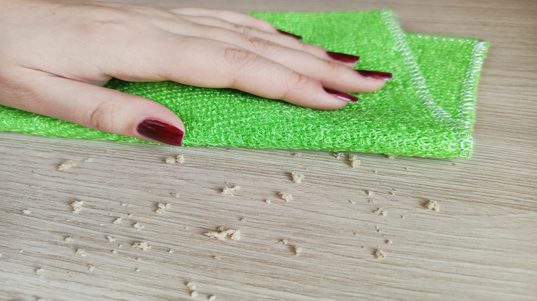 Close-up of woman using bamboo cloth to wipe counter