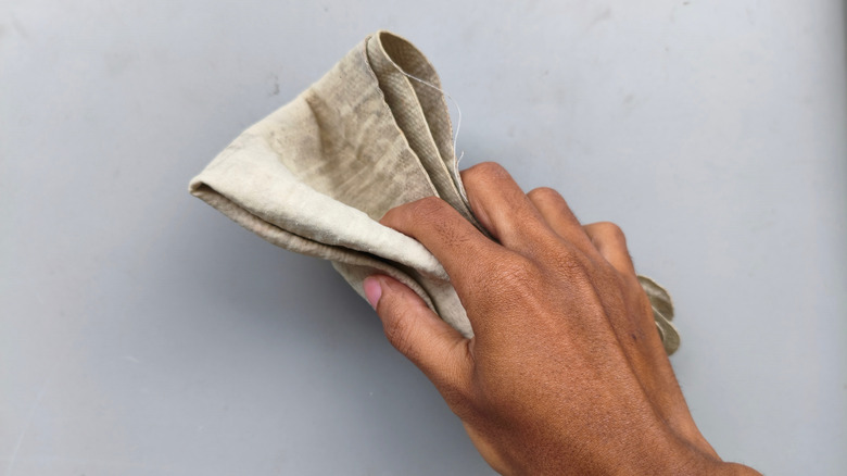 Close up of person wiping surface with chamois cloth towel