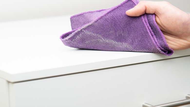 Close-up of person wiping counter with microfiber towel
