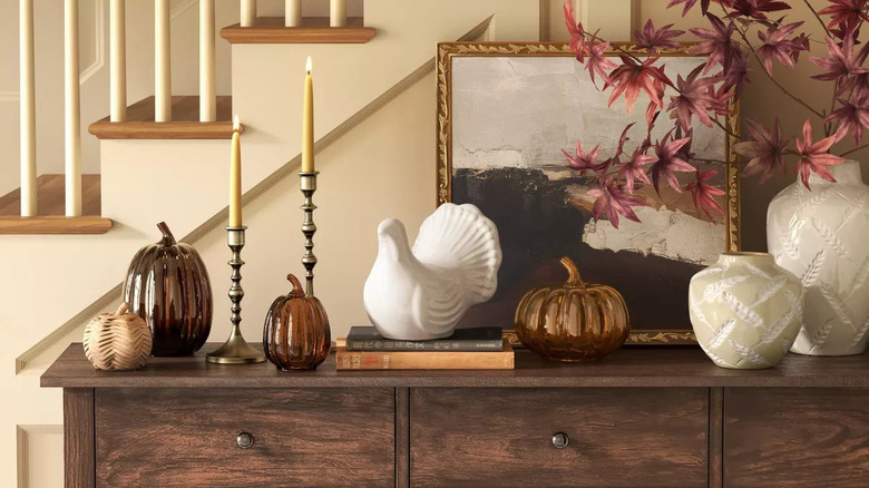 A fall decor setup on a table with glass decorative pumpkins