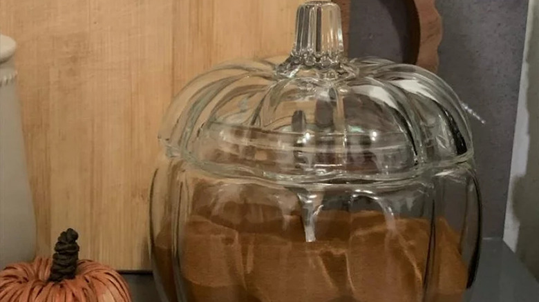 A glass pumpkin jar filled with coffee