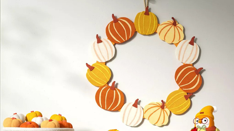 A orange, yellow, and white wreath hanging on a wall