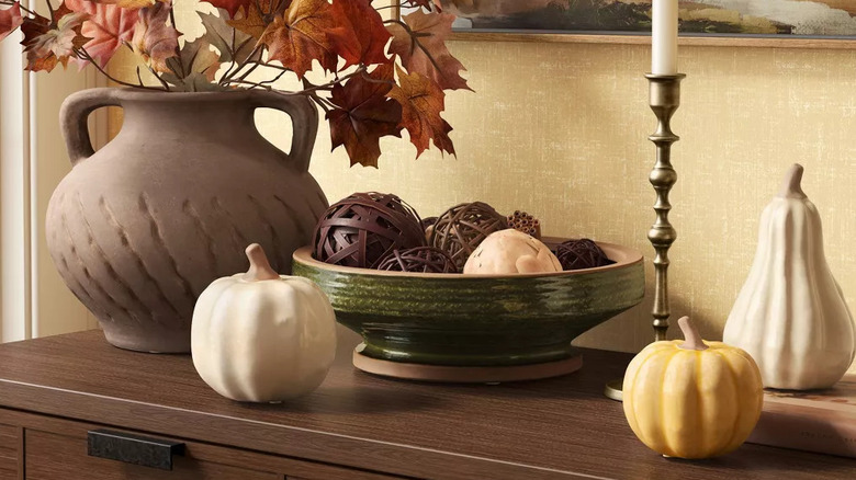 Fall decor pieces arranged on a table with ceramic pumpkins