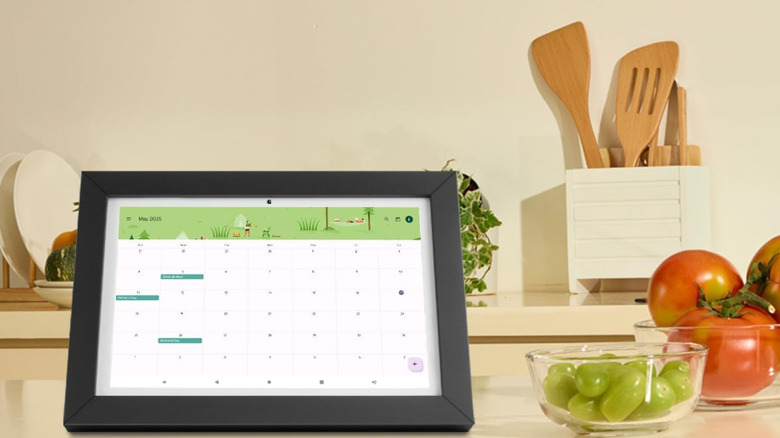 A small portable smart TV on a kitchen counter with produce.