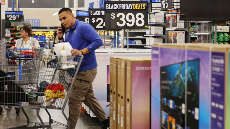 Shopper walking by Black Friday TV deals.