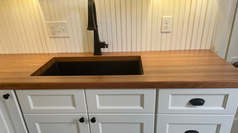 Cherry butcher block countertop around a kitchen sink