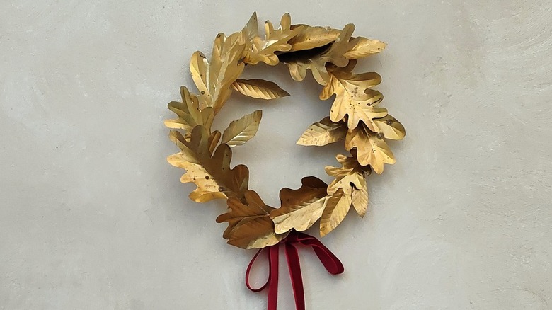 Brass-toned metal oak leaf wreath with red velvet bow