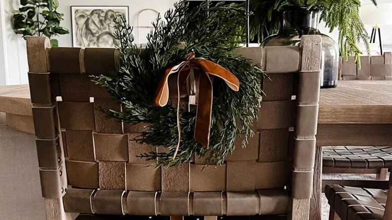 Mini cedar cabinet wreath with a ribbon on the back of a chair