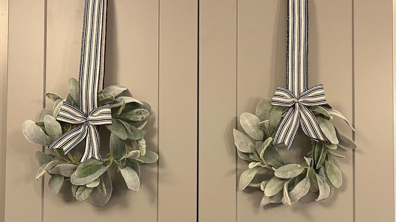 Mini lamb's ear wreaths hanging on a cabinet