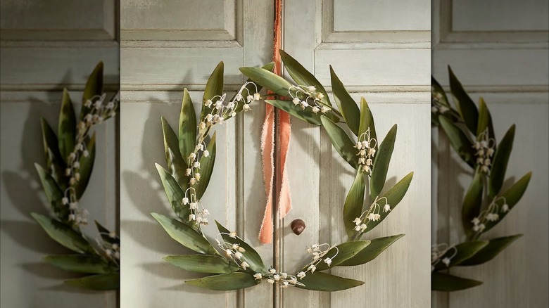 Lily-of-the-valley iron wreath hanging on a cabinet