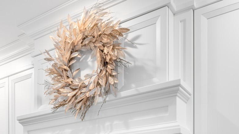 Faux-leaf wreath hanging on a cabinet
