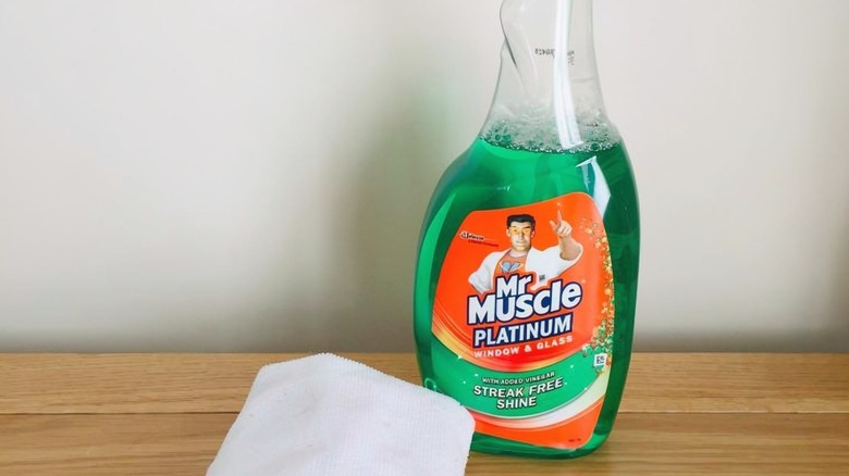 a bottle of Mr. Muscle Platinum Window & Glass Cleaner Spray next to a cloth