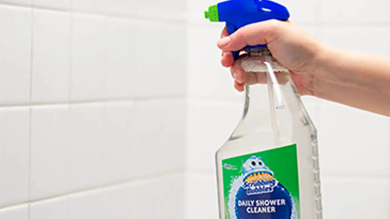 a persons praying the Scrubbing Bubbles Daily Shower and Cleaner Spray on a bathroom wall