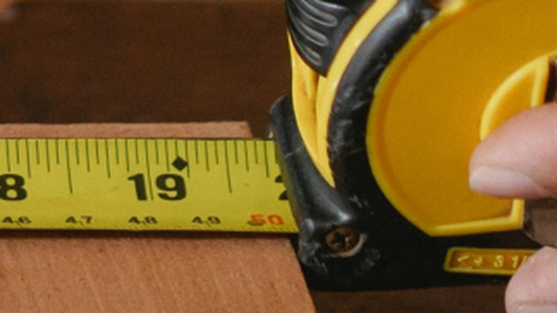 Close up of the 19 inch mark on a yellow and black tape measure with a black diamond