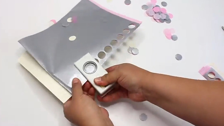 A hole puncher making confetti with wrapping paper