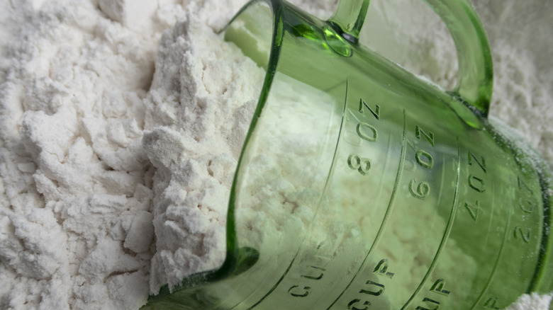measuring cup sitting in flour container