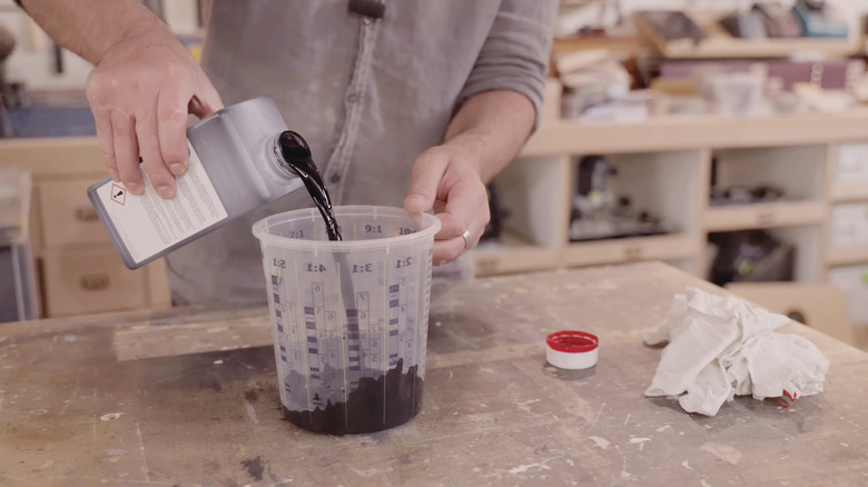 pouring paint into a measuring cup