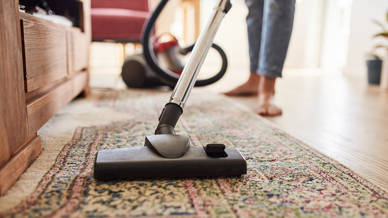 Person vacuuming rug