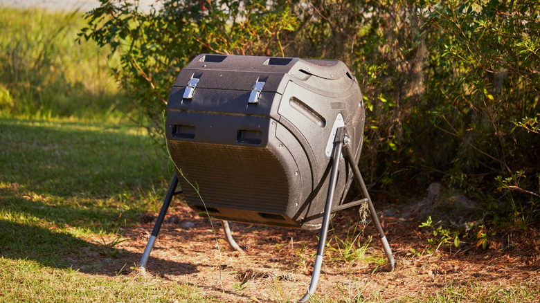 Black compost tumbler in a garden