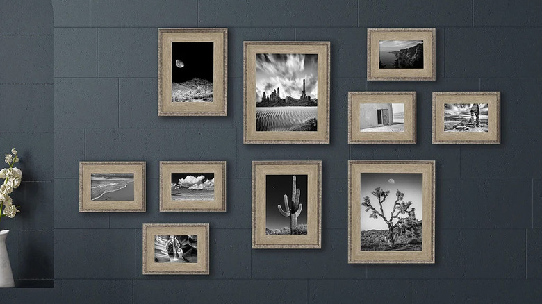 A gold 10-piece picture frame set displaying black and white photos on a gray wall