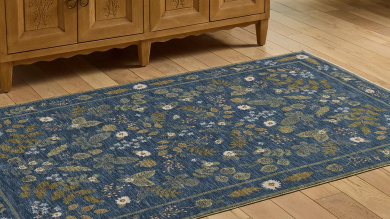 Large blue floral area rug on a wood floor