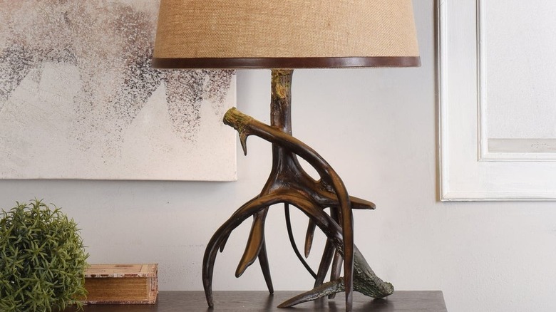 A rustic faux antler table lamp on a piece of wood furniture