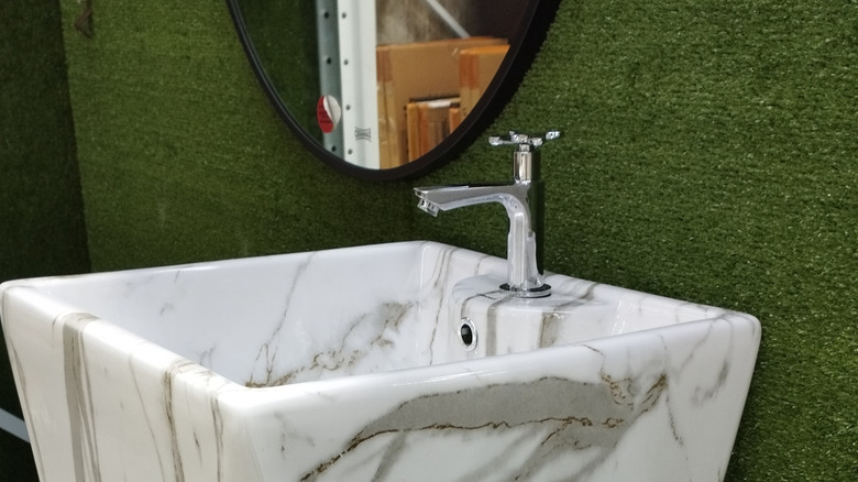 white marble sink by mirror